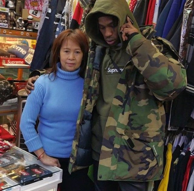 Travis Scott Poses Wearing Supreme Parka Jacket And Hoodie Amidst