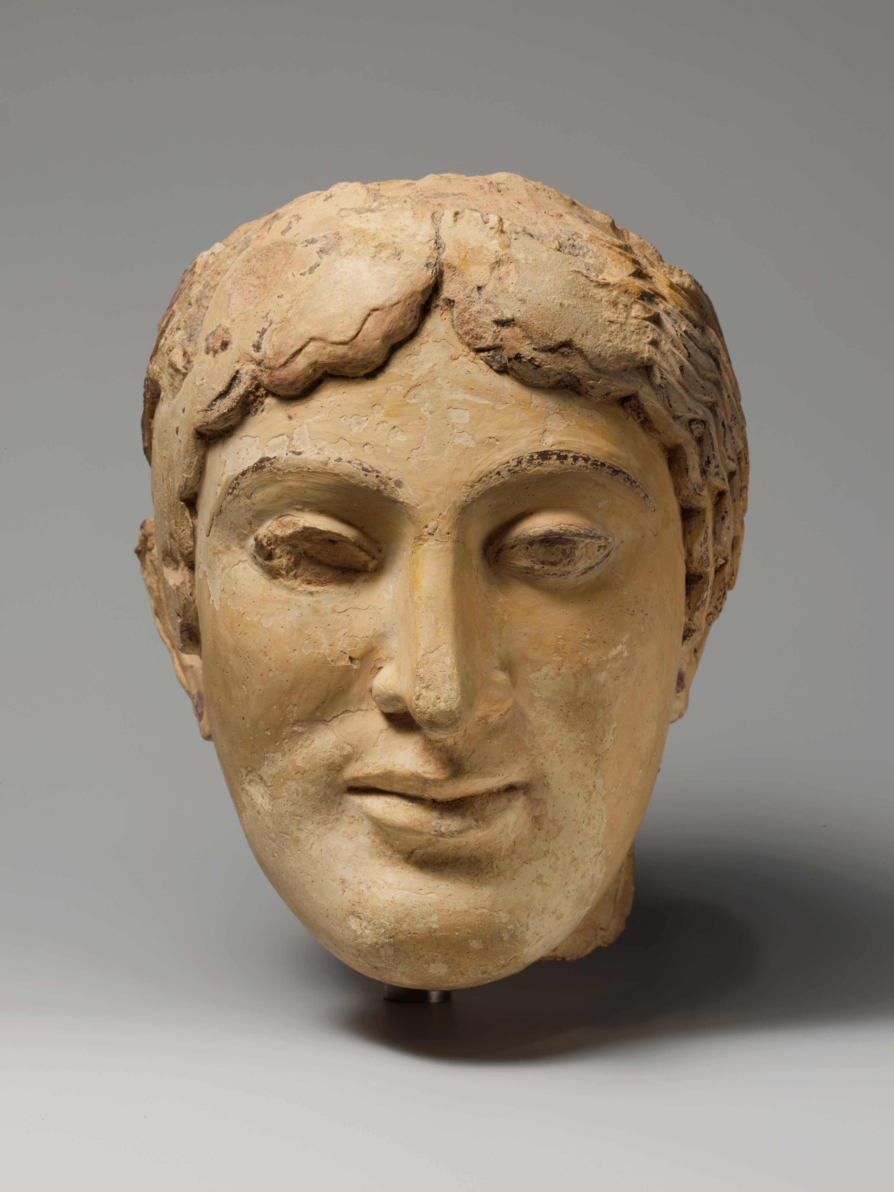 Terracotta head of a woman, probably a sphinx - Greek - Archaic
